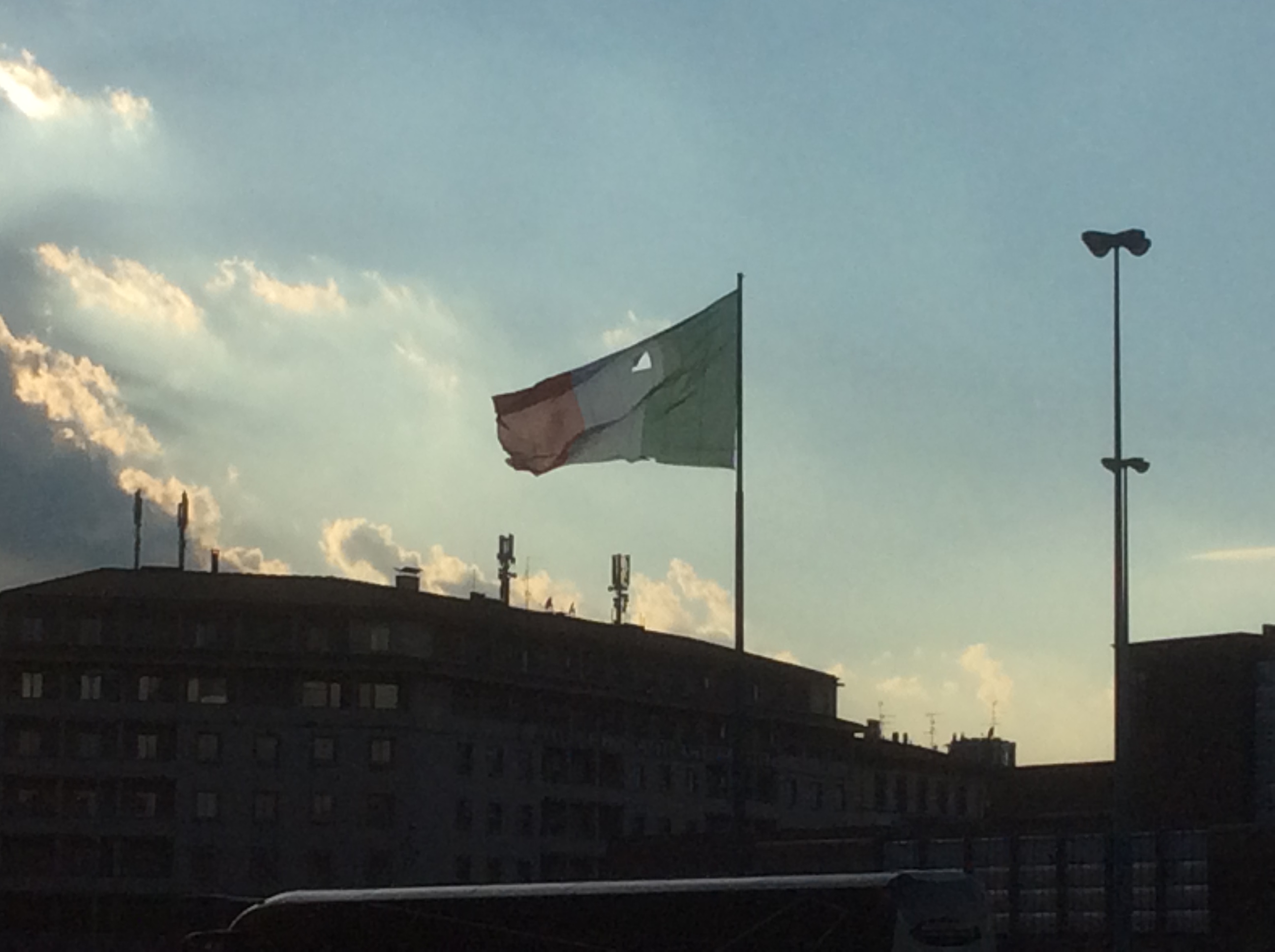 Grande Bandiera italiana bucata in piazza stazione