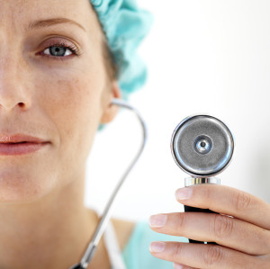 Female Doctor Wearing Protective Headgear and Using Stethoscope